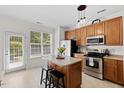 Bright kitchen with an island, stainless steel appliances, and natural light at 7613 Satinwing Ln, Raleigh, NC 27617