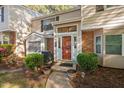 Inviting townhome entrance with potted plants and a storm door allowing light into the foyer at 7707 Falcon Rest Cir, Raleigh, NC 27615