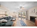 Open living room with hardwood floors, fireplace, ceiling fan, and access to outdoor space at 7707 Falcon Rest Cir, Raleigh, NC 27615