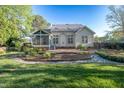 Spacious backyard with a screened-in porch, a stone patio, and lush landscaping at 906 Ingram Ct, Hillsborough, NC 27278