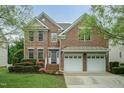 Charming brick two-story home featuring an attached two-car garage and manicured landscaping at 9225 Palm Bay Cir, Raleigh, NC 27617