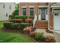 Close up of a brick front porch with beautiful flowering bushes at 9225 Palm Bay Cir, Raleigh, NC 27617