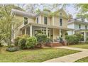 Attractive two-story home with a spacious front porch surrounded by mature trees and landscaping at 1005 W Lenoir St, Raleigh, NC 27603