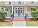 Welcoming front porch with classic columns and meticulously maintained landscaping, creating a warm entry at 1005 W Lenoir St, Raleigh, NC 27603