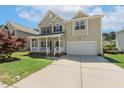 Traditional two-story home with a covered front porch, attached garage, and a green lawn at 1127 Woodlands Creek Way, Apex, NC 27502