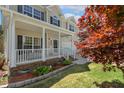 Inviting covered front porch with white railing, offering a cozy spot to relax and enjoy the outdoors at 1127 Woodlands Creek Way, Apex, NC 27502