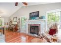 Bright living room with a brick fireplace, hardwood floors, and large windows with natural light at 13 Thorne Ridge Dr, Durham, NC 27713