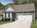 Charming single-Gathering home featuring a two-car garage and stone accents on a well-manicured lawn at 140 Clear Water Rd, Louisburg, NC 27549