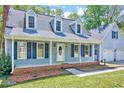 Charming front porch with blue siding, leading to a welcoming front door and two-car garage at 1433 Andersonwood Dr, Fuquay Varina, NC 27526