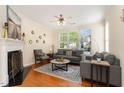 Cozy living room featuring hardwood floors, neutral tones, fireplace, and ample natural light from large windows at 162 Grey Elm Trl, Durham, NC 27713