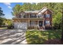 Charming two-story home with a combination of brick and siding, large driveway, and attached garage at 2 Piney Ridge Ct, Durham, NC 27712