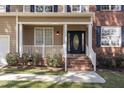 Inviting front porch with brick steps, white railings, and well-maintained landscaping at 2 Piney Ridge Ct, Durham, NC 27712