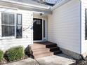 A welcoming front entrance featuring a dark-stained wood porch, black door with glass, and light-colored siding at 211 Milky Way Dr, Apex, NC 27502