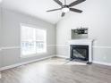 A bright living room featuring a fireplace, high ceilings, wood floors and a ceiling fan at 211 Milky Way Dr, Apex, NC 27502
