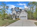 Newly constructed farmhouse with a two-car garage, white siding, black shutters, and a manicured lawn at 2432 Spindle Ct, Raleigh, NC 27603