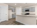 Open concept kitchen with gray cabinets, granite countertops, and stainless steel appliances at 270 Palm Dr, Sanford, NC 27330