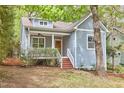 Charming home with light blue siding, a front porch, and beautiful mature trees surrounding the property at 2814 Sarah Ave, Durham, NC 27707
