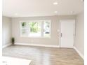 Bright living room with hardwood floors, a large window, white trim and a white door at 2824 Wyncote Drive, Raleigh, NC 27603