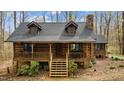 Charming log cabin featuring a stone foundation, cozy porch, and rustic charm at 2931 Western Hills Ln, Elon, NC 27244