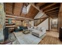 Cozy living room featuring exposed beams, a large rug, and comfortable seating at 2931 Western Hills Ln, Elon, NC 27244