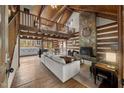 A spacious living room with a stone fireplace, wood beams, and a view of the kitchen at 2931 Western Hills Ln, Elon, NC 27244