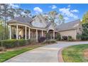 Inviting exterior view featuring a covered porch with rocking chairs and a spacious driveway at 3016 Allansford Ln, Raleigh, NC 27613