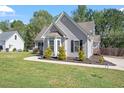 Gray home with an attached garage, bay window, and tidy front lawn at 310 Cedarhurst Ln, Franklinton, NC 27525