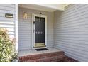 Close-up of the home's front door, framed by brick steps and gray siding at 310 Cedarhurst Ln, Franklinton, NC 27525