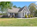Quaint one-story home with gray siding, black shutters, and green grass at 310 Cedarhurst Ln, Franklinton, NC 27525