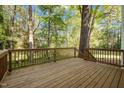 A wooden deck offers a view of the backyard with mature trees and green space at 3514 Shady Creek Dr, Durham, NC 27713