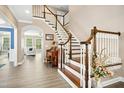 Elegant foyer featuring hardwood floors, a staircase with white balusters, and a view of the living room at 44 S Wilders Ridge Way, Clayton, NC 27527
