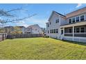 Spacious backyard with lush green grass, a privacy fence, and covered porch at 490 Boulder Point Dr, Chapel Hill, NC 27516