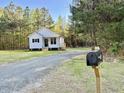 Beautiful shot of the property featuring mature trees and long gravel driveway at 50 Lakewood Dr, Roxboro, NC 27573