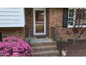 Charming brick home entrance featuring a cozy front porch and beautiful pink flowers in a well-maintained landscape at 505 Forest Road Rd, Oxford, NC 27565