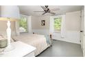 Cozy bedroom featuring two windows, a ceiling fan and neutral decor, providing a relaxing atmosphere at 509 N Elm St, Benson, NC 27504