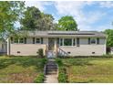 Charming single-story home with a brick facade, a metal roof, and a well-manicured lawn and mature trees at 513 Hugo St, Durham, NC 27704