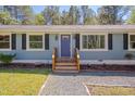 Inviting blue front door with black shutters and blooming flower beds at 5604 Bobcat Rd, Chapel Hill, NC 27516