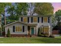 Charming two-story home with vinyl siding, black shutters, a well-manicured lawn, and a brightly colored teal front door at 601 E Dynasty Dr, Cary, NC 27513