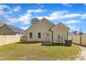 Large backyard featuring a new wooden fence, lush green lawn, and exterior home features at 617 Ray St, Selma, NC 27576