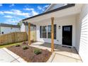 Inviting front porch with natural wood columns, black door, and landscaped garden at 617 Ray St, Selma, NC 27576