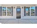 Close-up of front door flanked by windows with black shutters and sconces at 619 Ray St, Selma, NC 27576