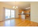 Open dining area with hardwood floors, light fixture, and sliding glass doors to outdoor space at 627 Carraway Dr, Graham, NC 27253