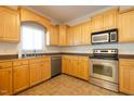 Bright kitchen featuring stainless steel appliances, light wood cabinetry and a neutral countertop at 627 Carraway Dr, Graham, NC 27253