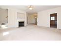 Spacious living room with fireplace, neutral carpeting, and views into the dining and kitchen areas at 627 Carraway Dr, Graham, NC 27253