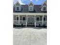 Close up of the full front porch and front door of this charming tan home at 6283 Harrisontown Rd, Rocky Mount, NC 27804