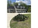 Beautiful tan home with a full front porch, mature trees, and concrete driveway at 6283 Harrisontown Rd, Rocky Mount, NC 27804
