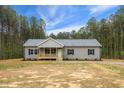 Inviting single-story home with gray vinyl siding, a covered porch, black shutters, and a well-maintained yard at 6312 Briddle Dr, Wendell, NC 27591