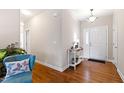 Bright foyer featuring hardwood floors, a console table, and a view of the front door at 6819 Franklin Heights Rd, Cary, NC 27518