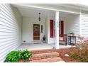 Inviting front porch with brick steps, decorative columns, and a charming seating area at 6819 Franklin Heights Rd, Cary, NC 27518