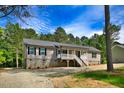 Charming single-story home with gray siding, stone foundation, and a welcoming front porch at 7122 Guess Rd, Hillsborough, NC 27278
